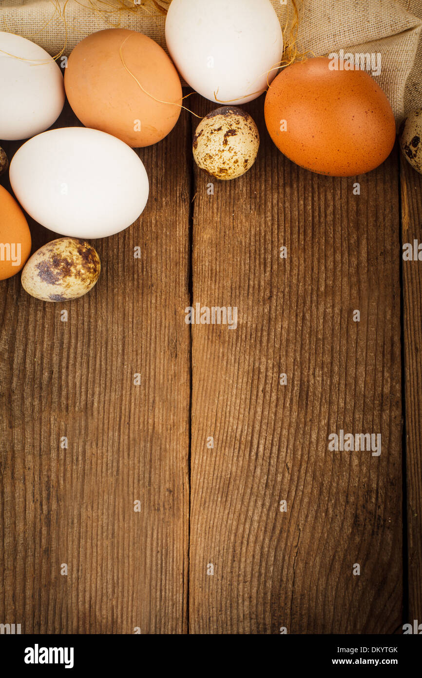 Eggs on textile tablecloth over rustic wooden table with copyspace Stock Photo