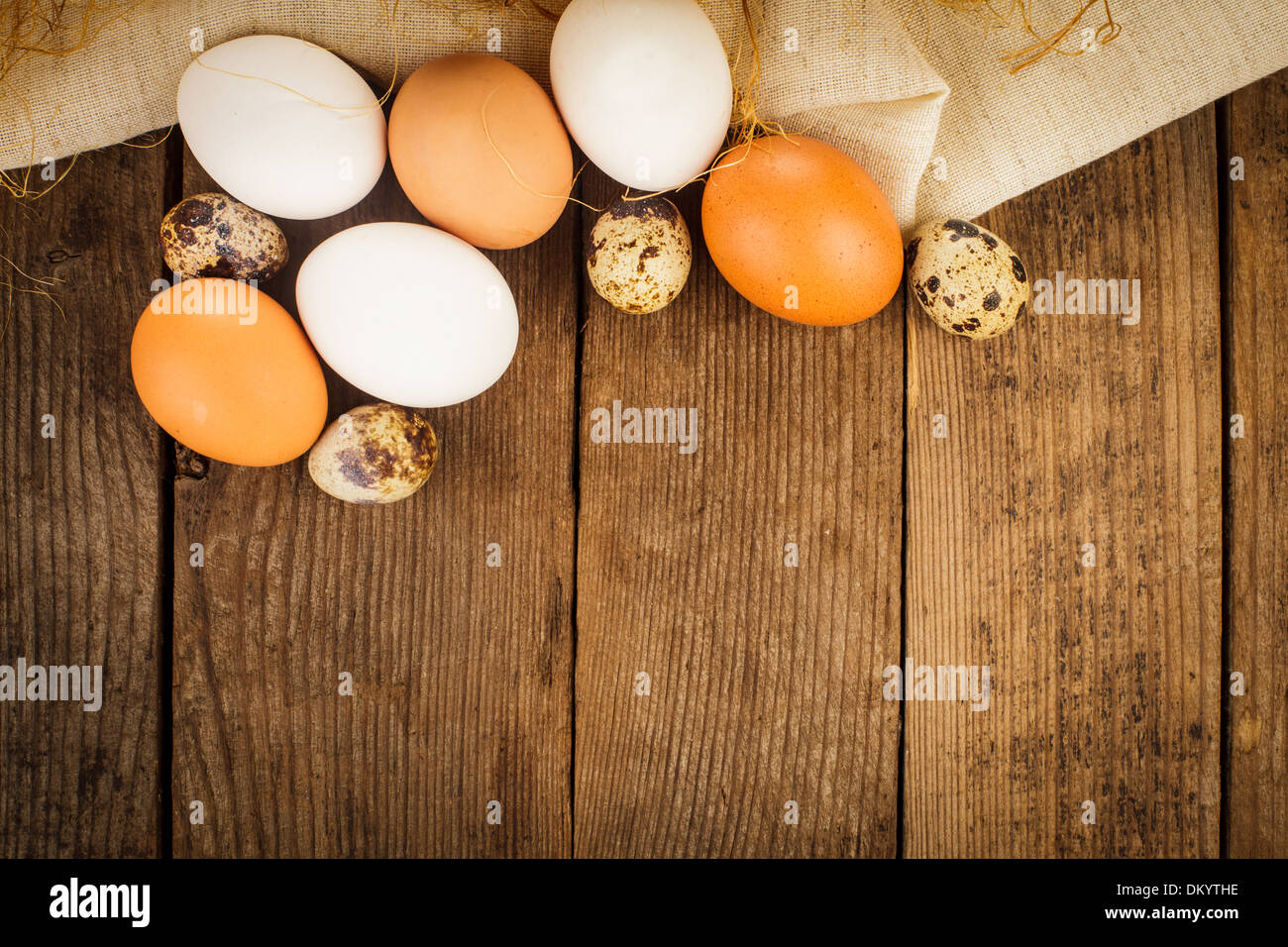 Eggs on textile tablecloth over rustic wooden table with copyspace Stock Photo