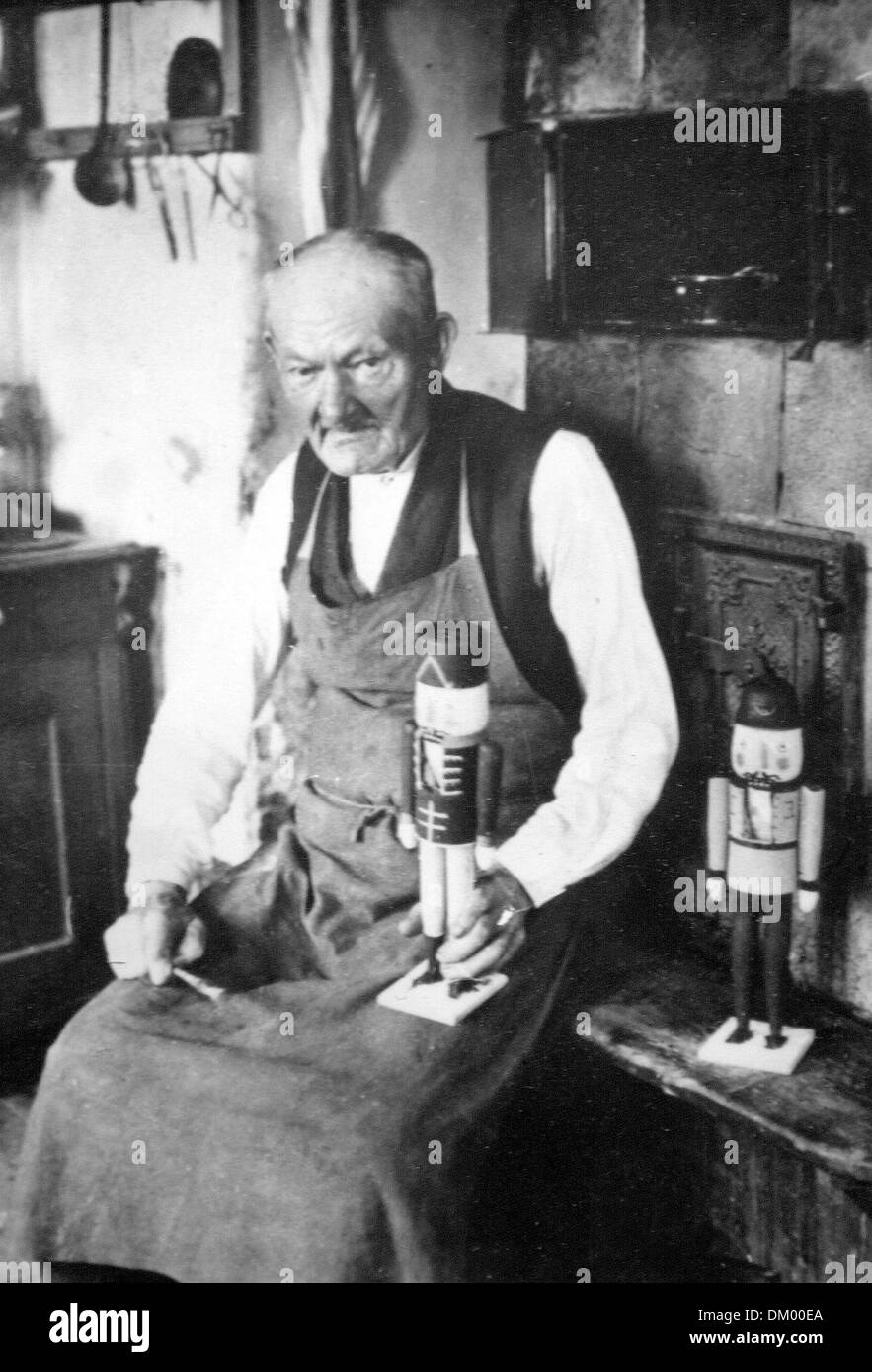An undated historical photograph shows Wilhelm Fürster with two wooden nutcrackers in his workshop in Seiffen in the Ore Mountains. At the start of the 18th century, the first wooden nutcracker was produced in the Füchter workshop. The nutcrackers they produced in the shape of kings, miners, and sultans and painted with many colours. Photo: private Stock Photo