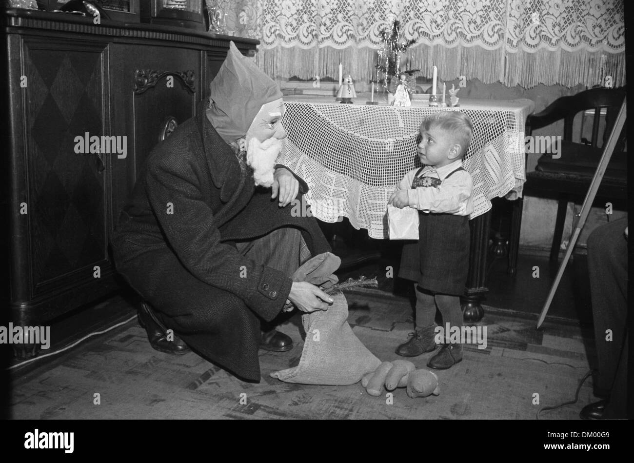 A small boy is pictured with Santa Claus on Christmas Eve in 1951. Photo: Deutsche Fotothek/Rössing Stock Photo