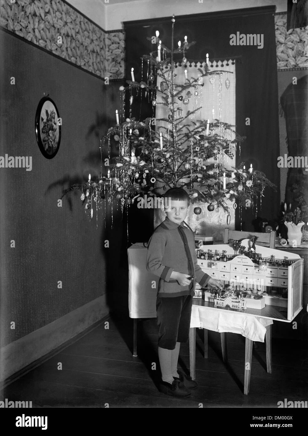 A boy is pictured with a toy shop beneath the Christmas tree, undated photography (around 1925/30). Photo: Deutsche Fotothek / A. Böttcher Stock Photo