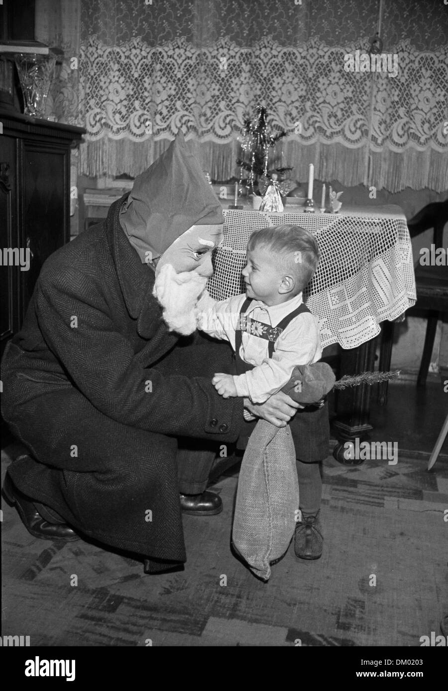 A small boy is pictured with Santa Claus on Christmas Eve in 1951. Photo: Deutsche Fotothek/Rössing Stock Photo