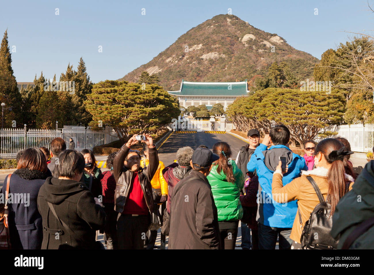 Visitors taking pictures in front of the main entrance of Cheongwadae (Blue House / Pavilion of Blue Tiles) - Seoul, South Korea Stock Photo
