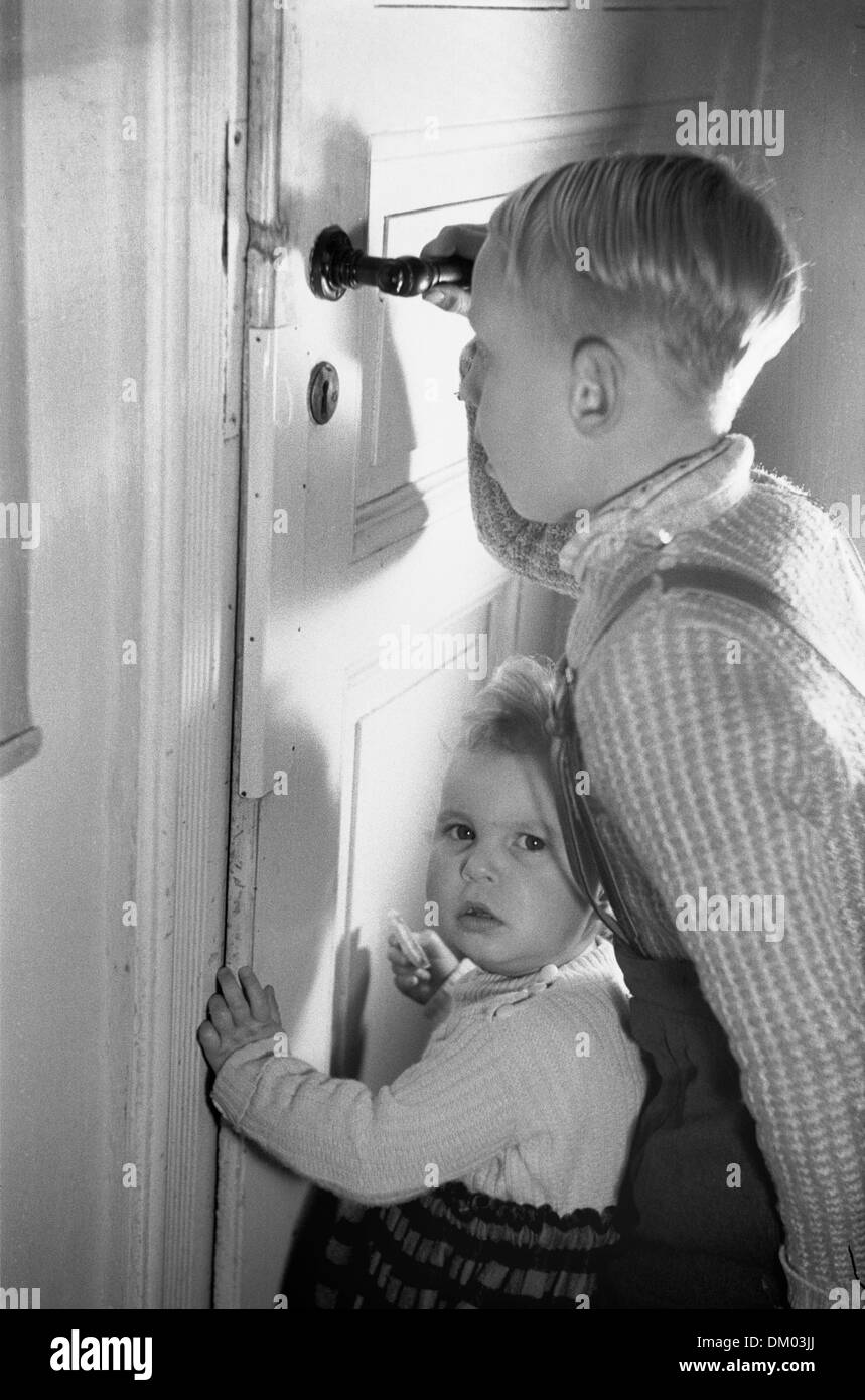 A child peeks through keyhole of a door - Christmas secrecy. Photo: Deutsche Fotothek/Rössing Stock Photo