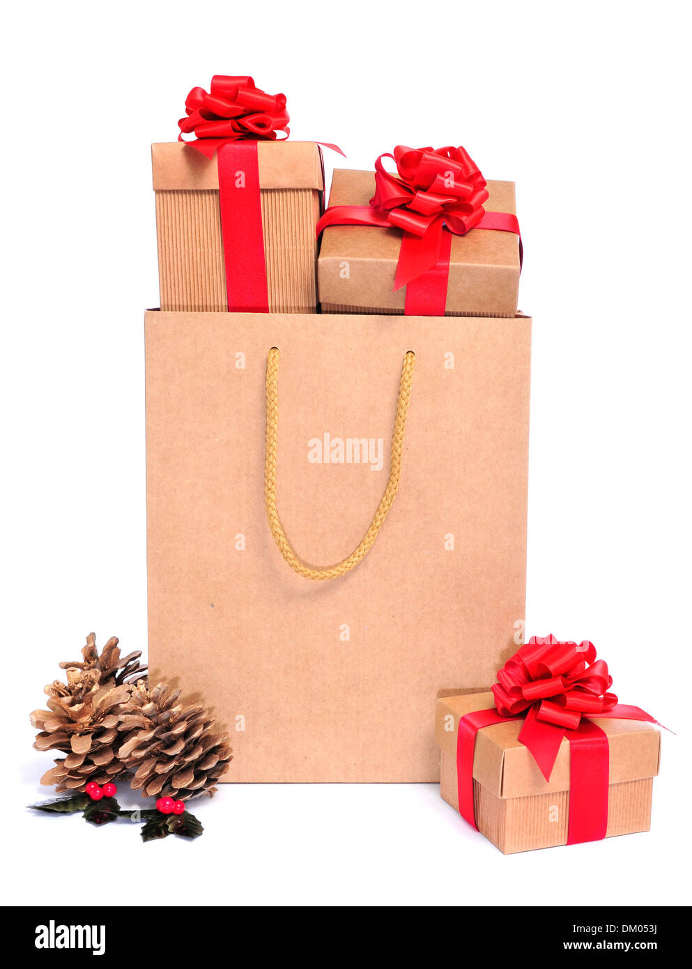 a pile of gifts with a red ribbon in a shopping bag and some golden pinecones on a white background Stock Photo