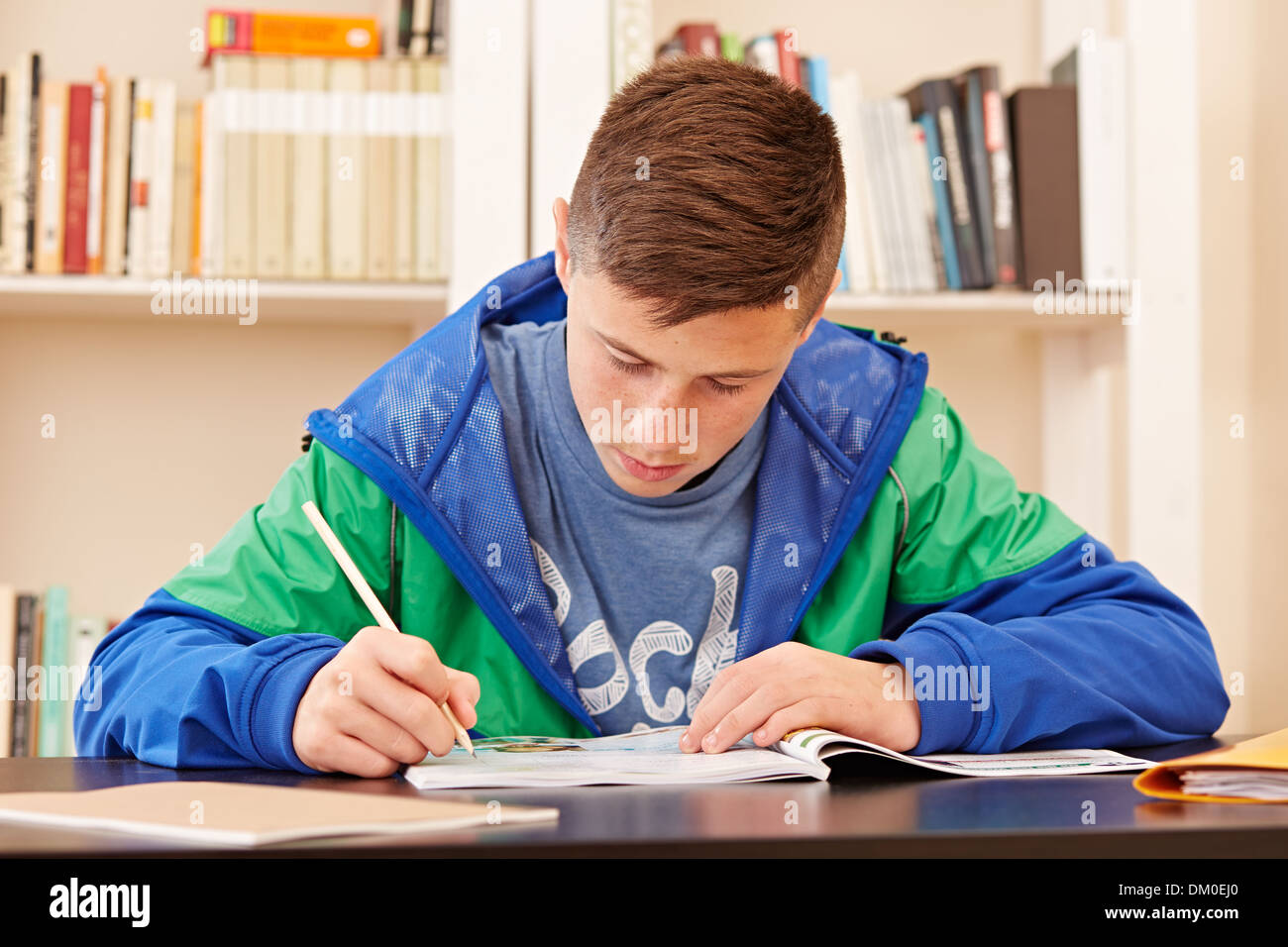 Male teenager concentrated doing homework in a desk Stock Photo Alamy
