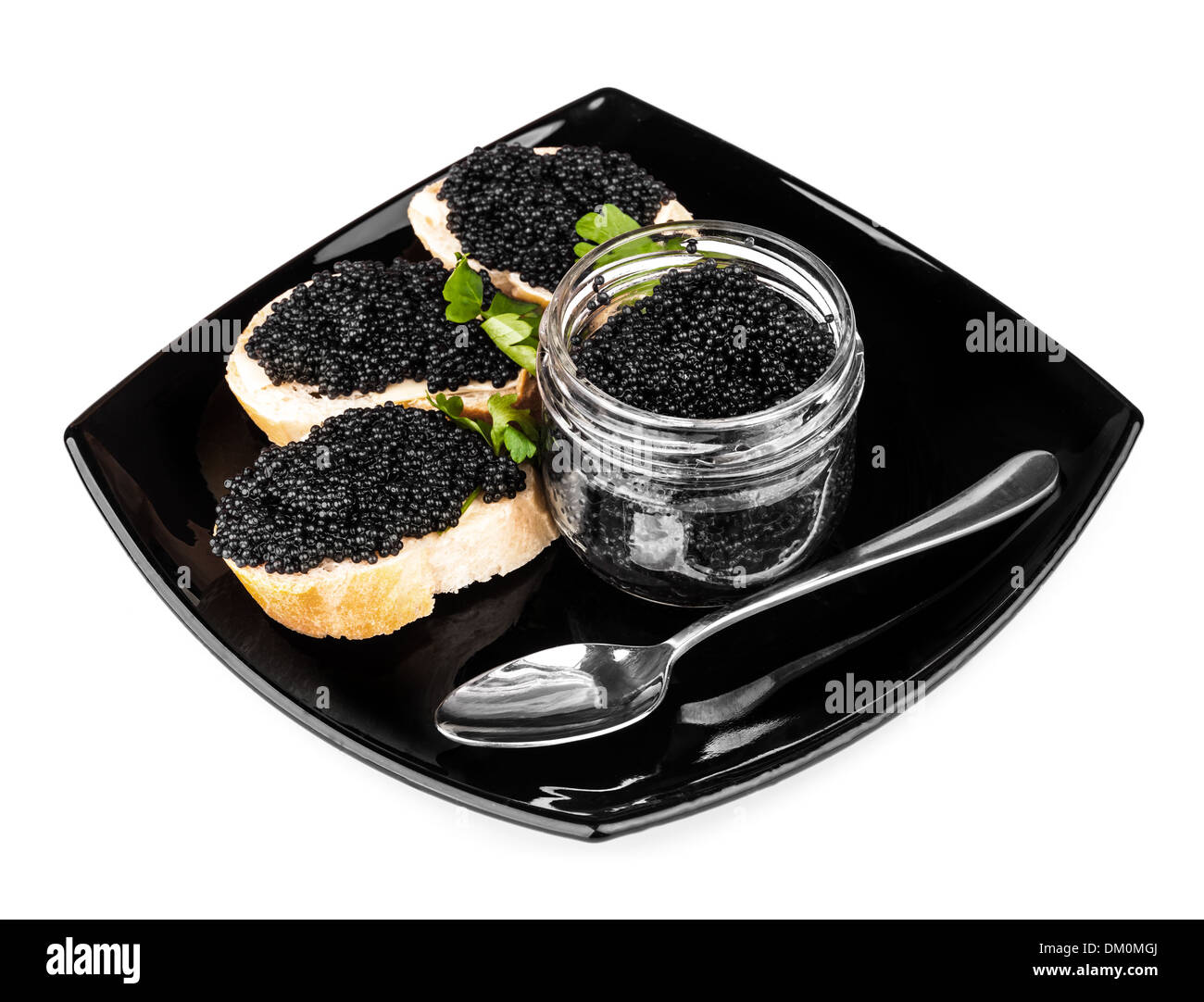 Sandwiches with black caviar and spoon on dark plate Stock Photo