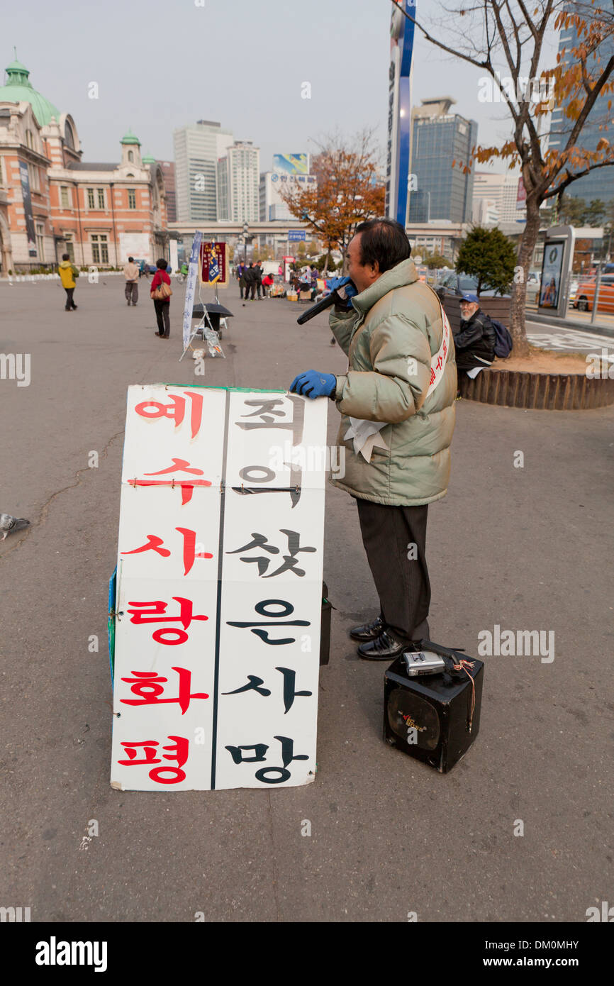 Street evangelist - Seoul, South Korea - Sign reads: Love for Jesus brings Peace, Sin's Reward is Death Stock Photo