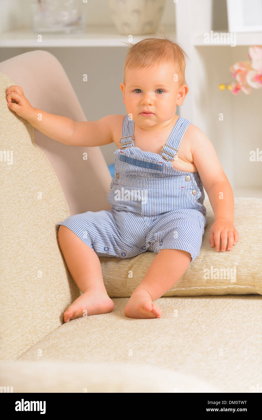 Adorable little barefoot boy sitting hires stock photography and