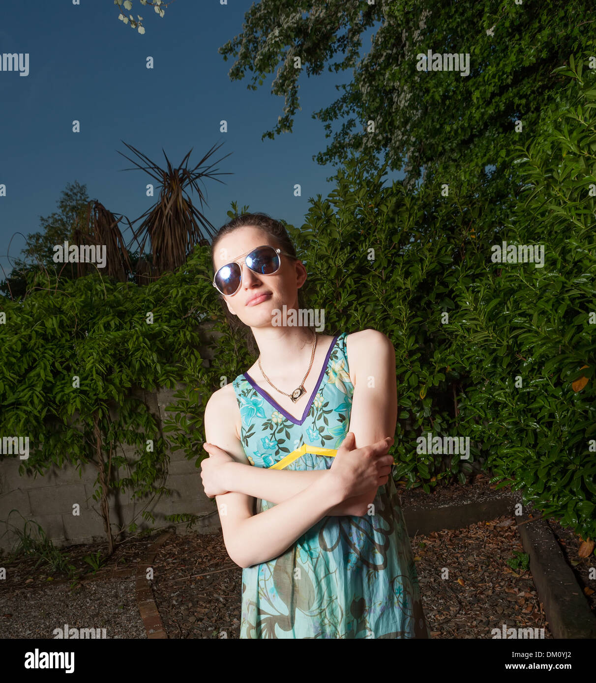 Female model wearing sunglasses in bright sunshine Stock Photo