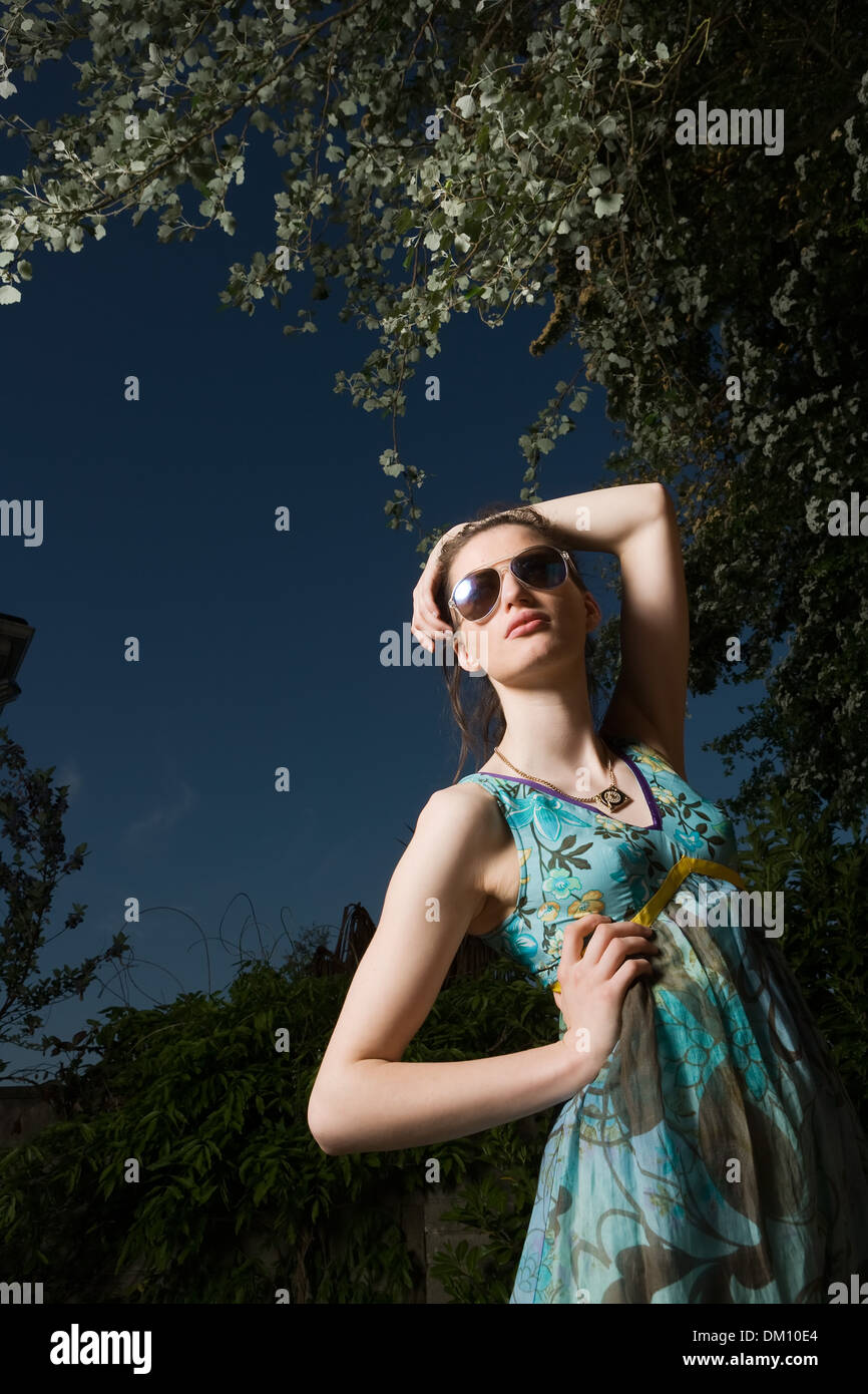 Female model wearing sunglasses in bright sunshine Stock Photo