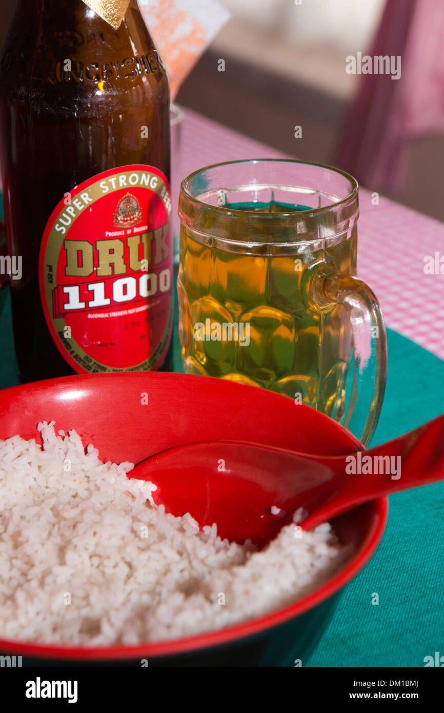 Bhutan, Bhutanese drink, glass of Druk 11000 strong beer, with bottle and rice for lunch Stock Photo