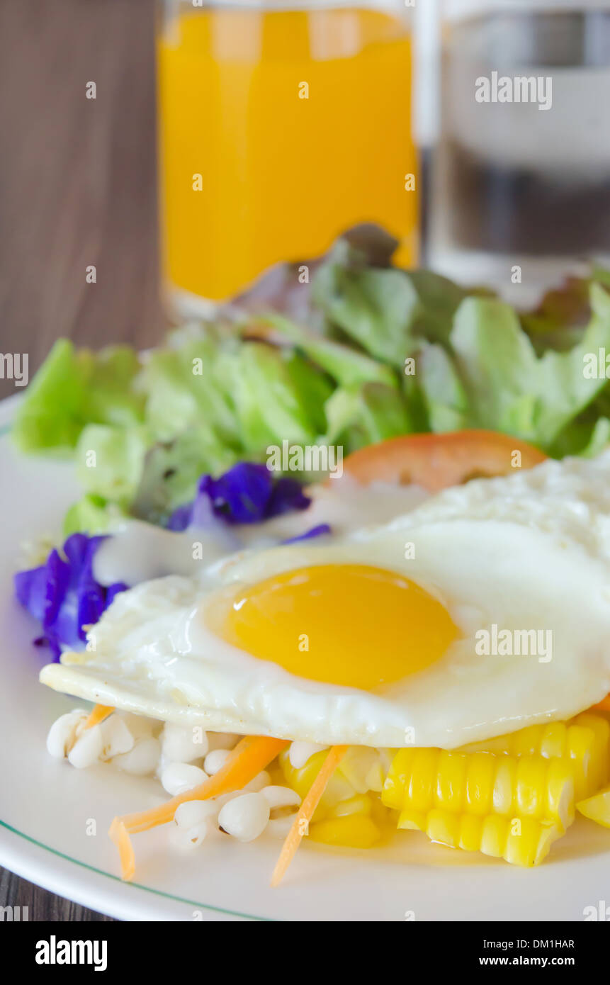 fried egg and fresh salad on dish Stock Photo