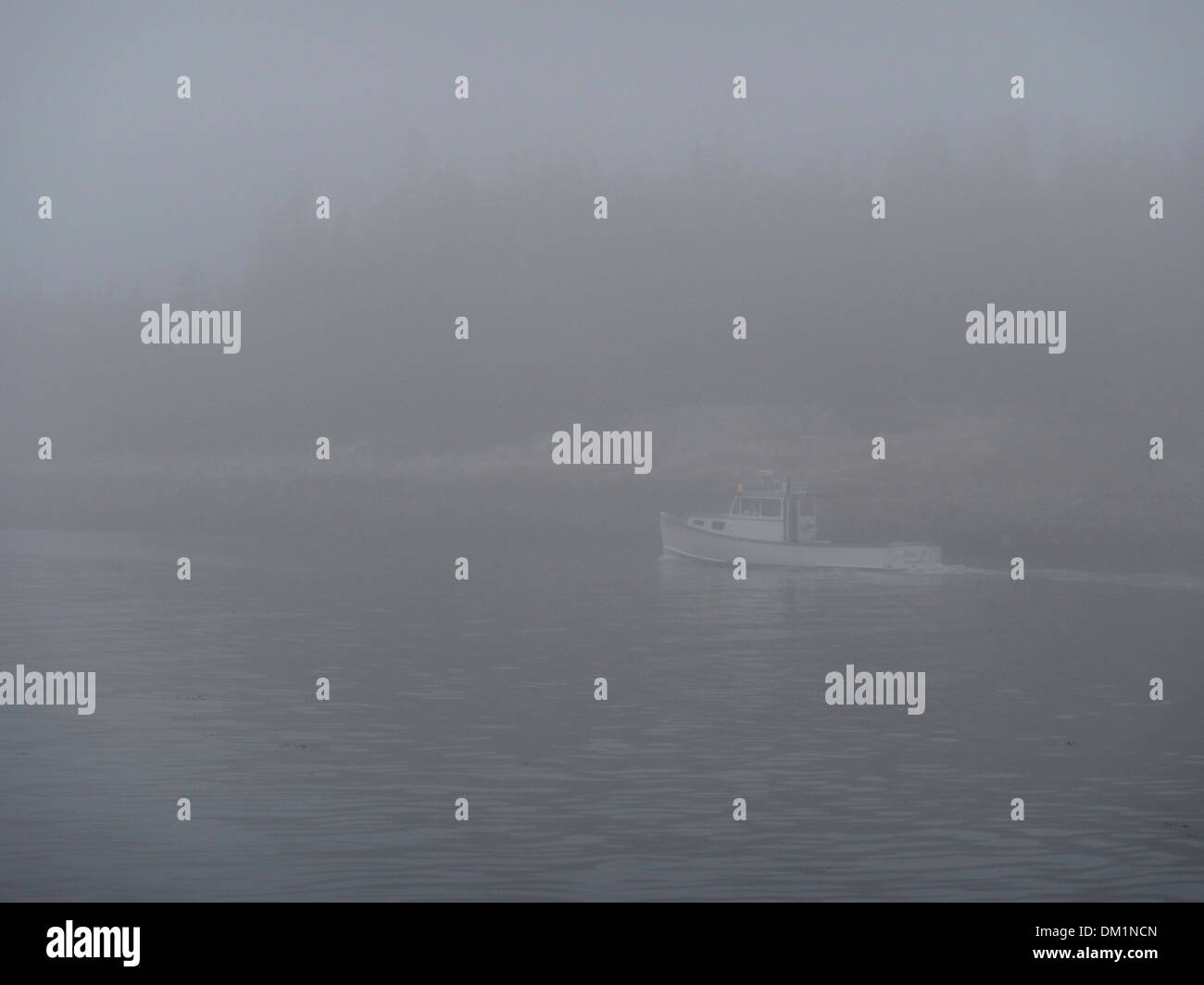 A lone lobster boat heads home in the heavy fog in downeast Maine. Stock Photo