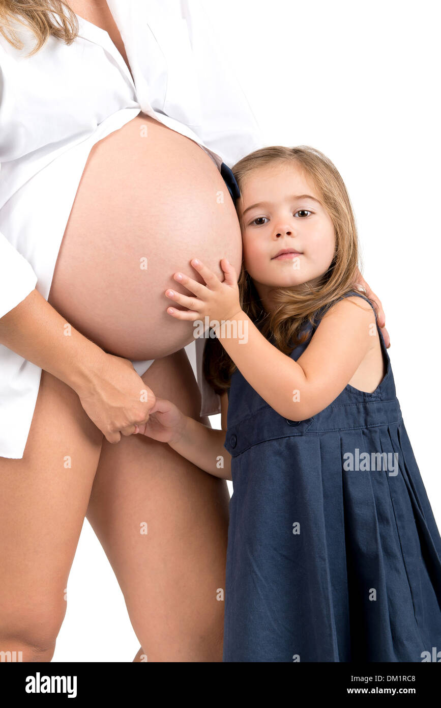 Beautiful young girl holding pregnant mother's belly Stock Photo