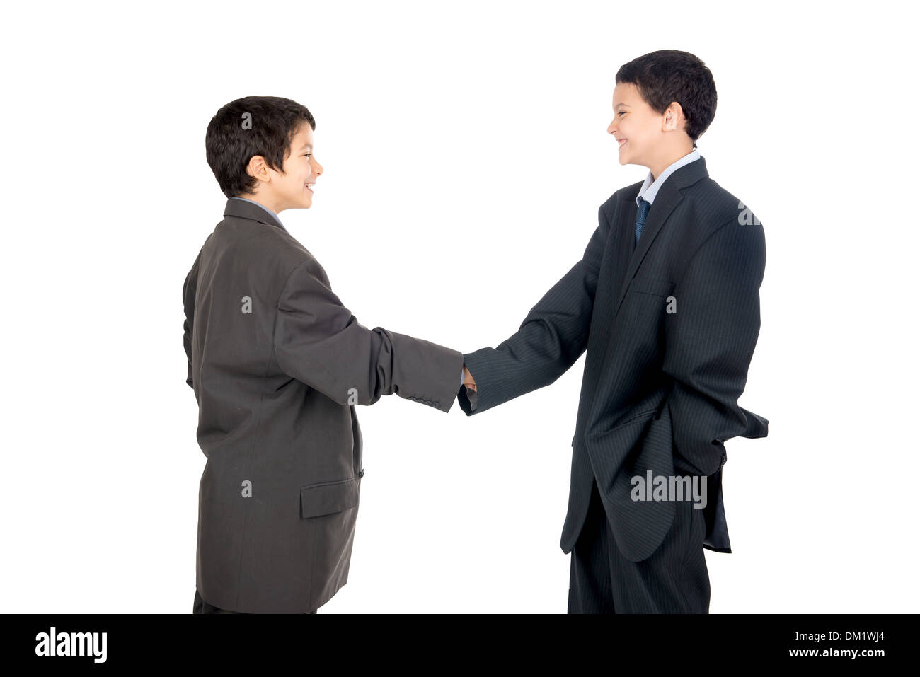 Young boys dressed with a big man's suit shaking hands Stock Photo