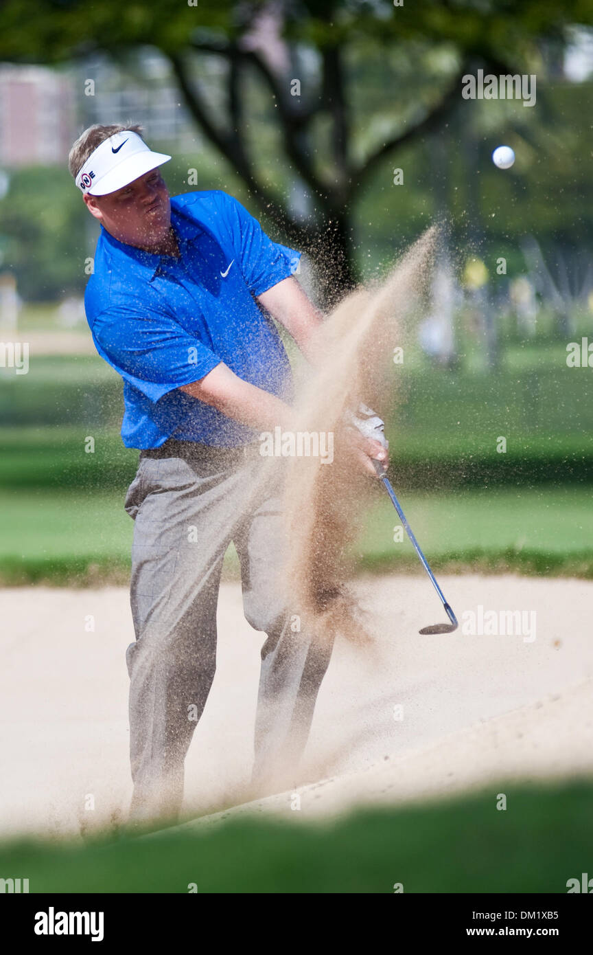 Carl Patterson chips out of a green-side bunker on the 9th hole. The ...