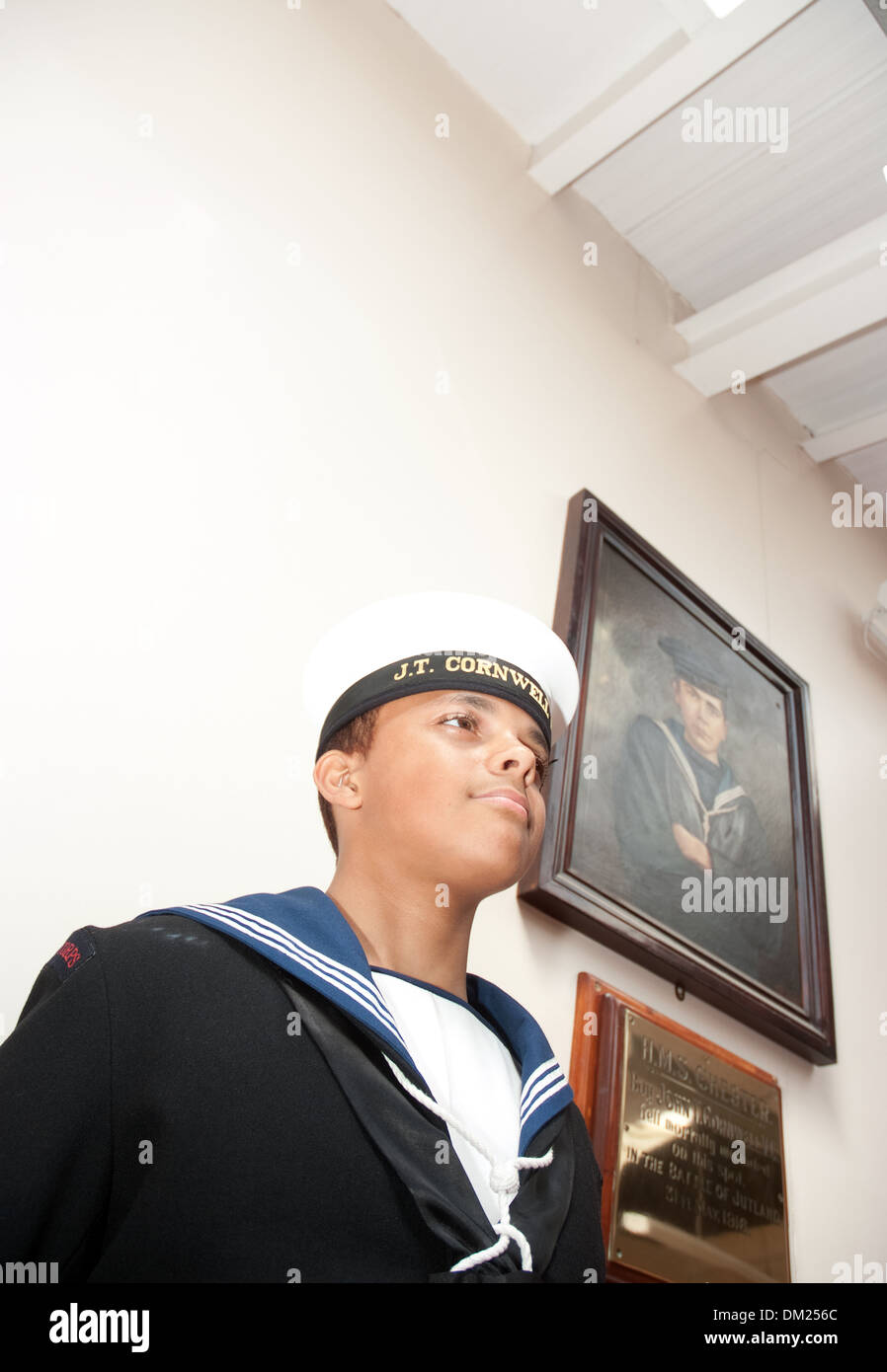 A Sea Cadet stands  along side, a painting of John Travers Cornwell VC . (The portrait of Cornwell, artist used his brother ) Stock Photo