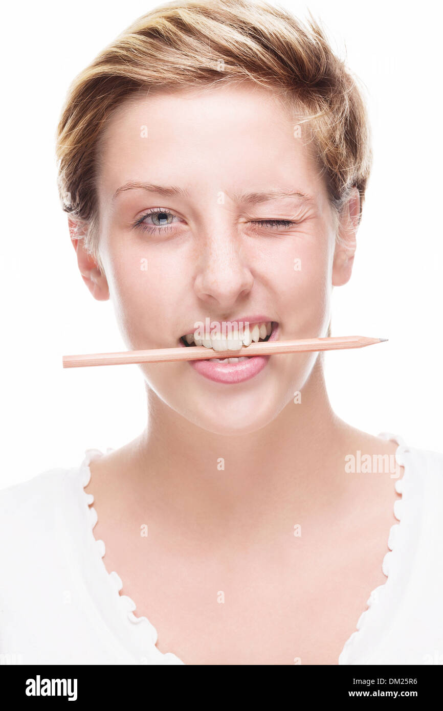 blonde happy woman winking with pencil in her mouth on white background ...