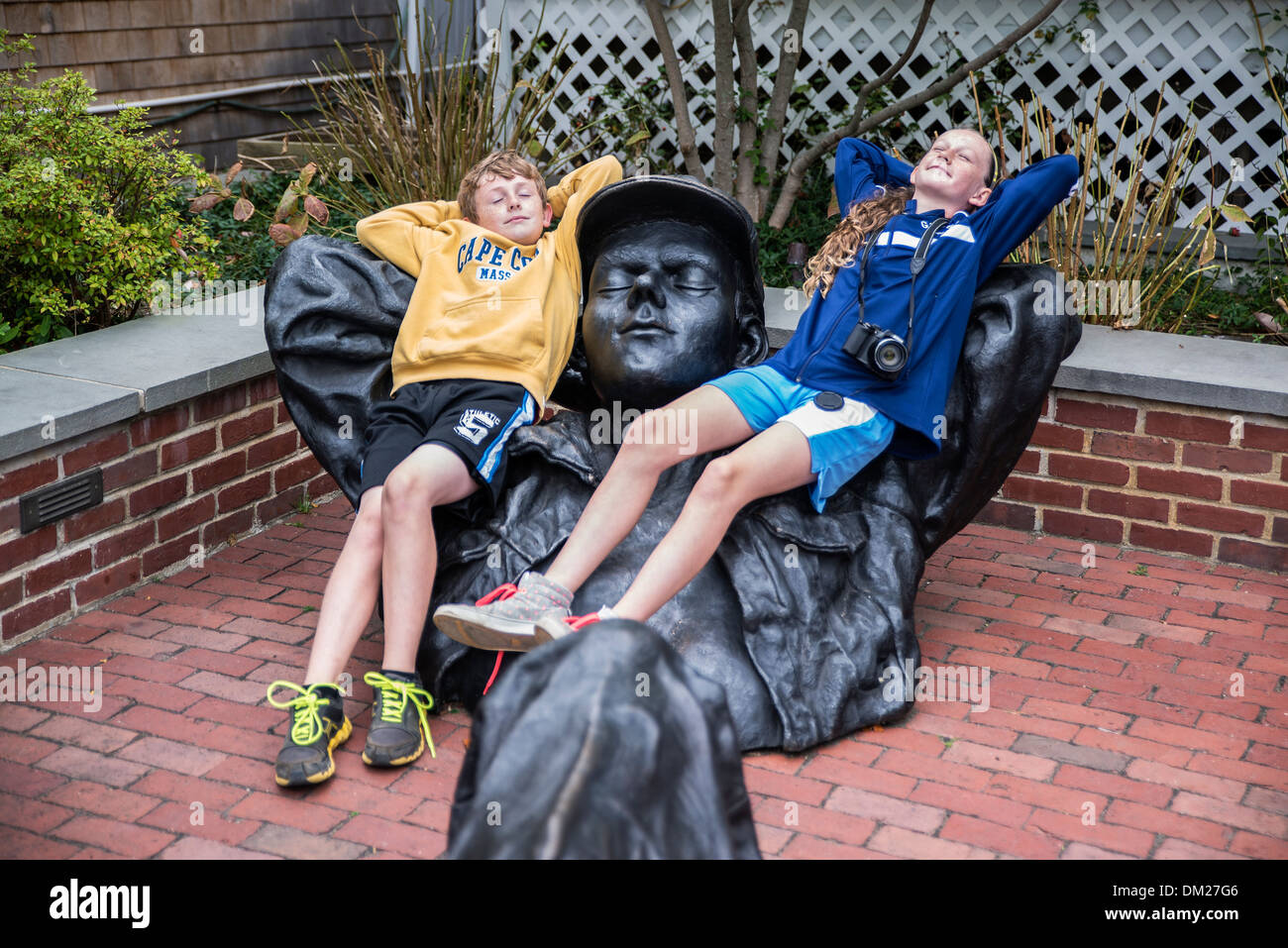 Siblings relax with a sculpture, Edgartown, Martha's Vineyard, Massachusetts, USA Stock Photo