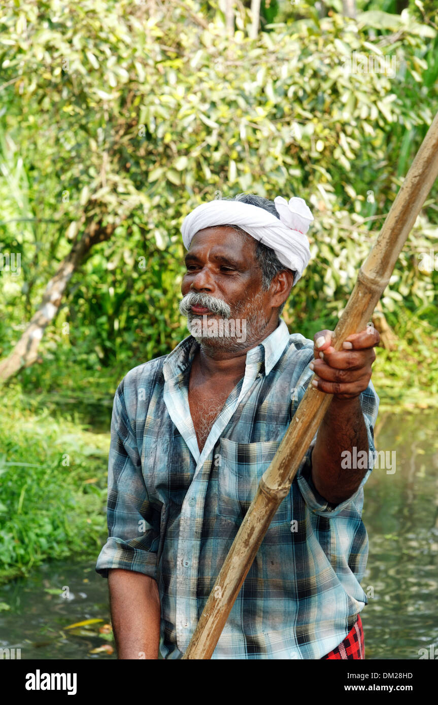 An Indian man punting in the Kerala backwaters Stock Photo