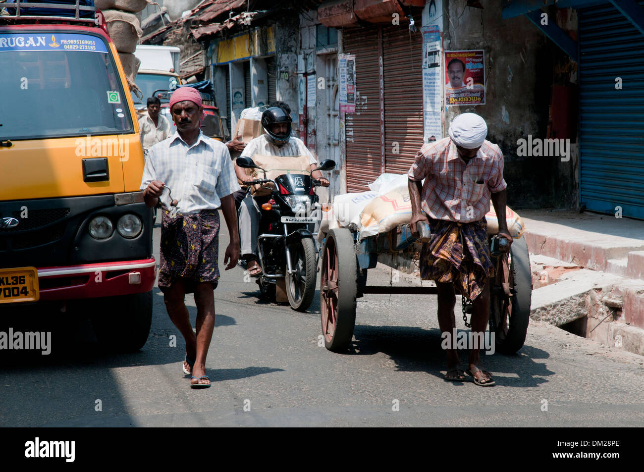 An Indian man with a heavy hand cart Stock Photo