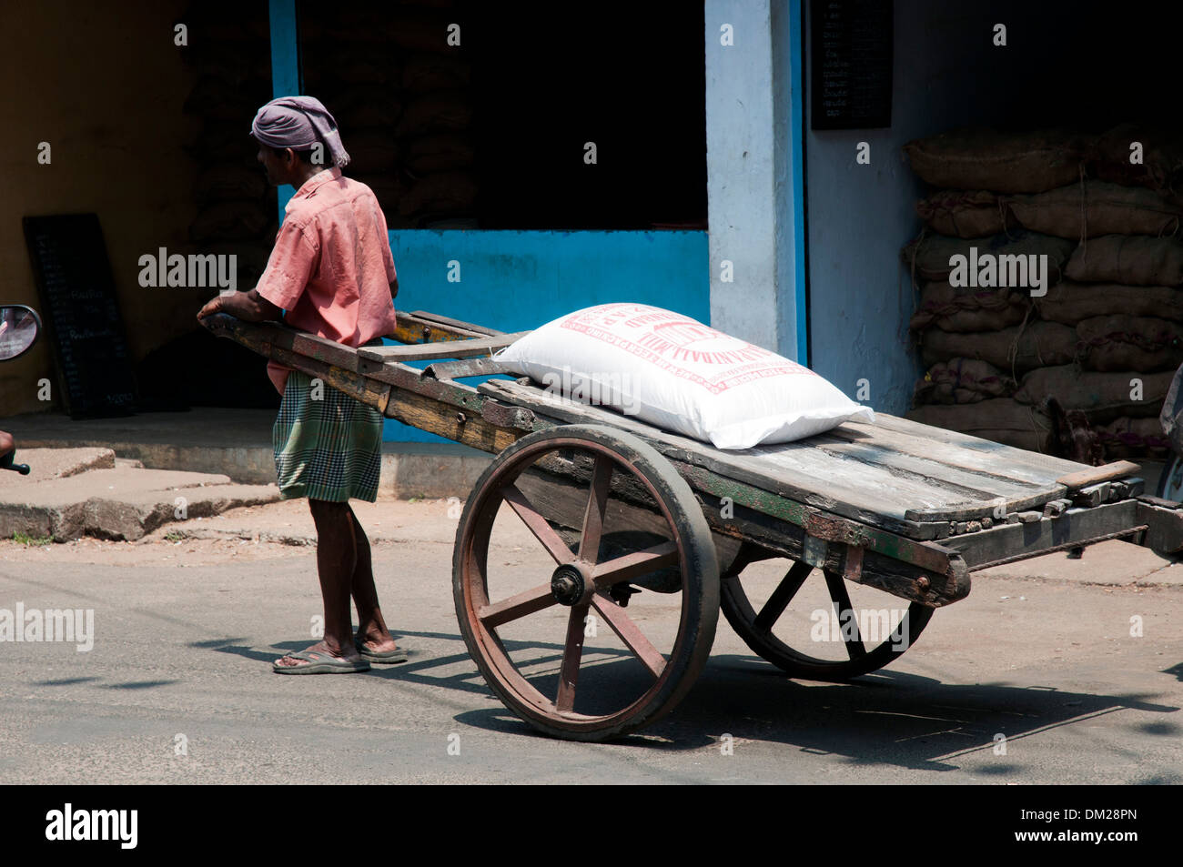 An Indian man with a heavy hand cart Stock Photo