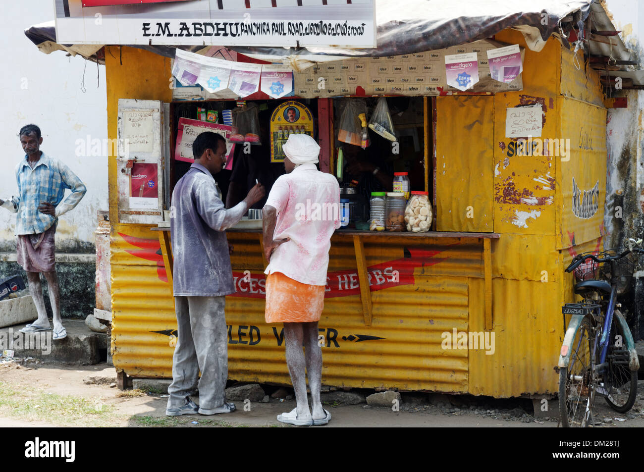 Indian workers buying sweets from a fast food kiosk in Kochin India