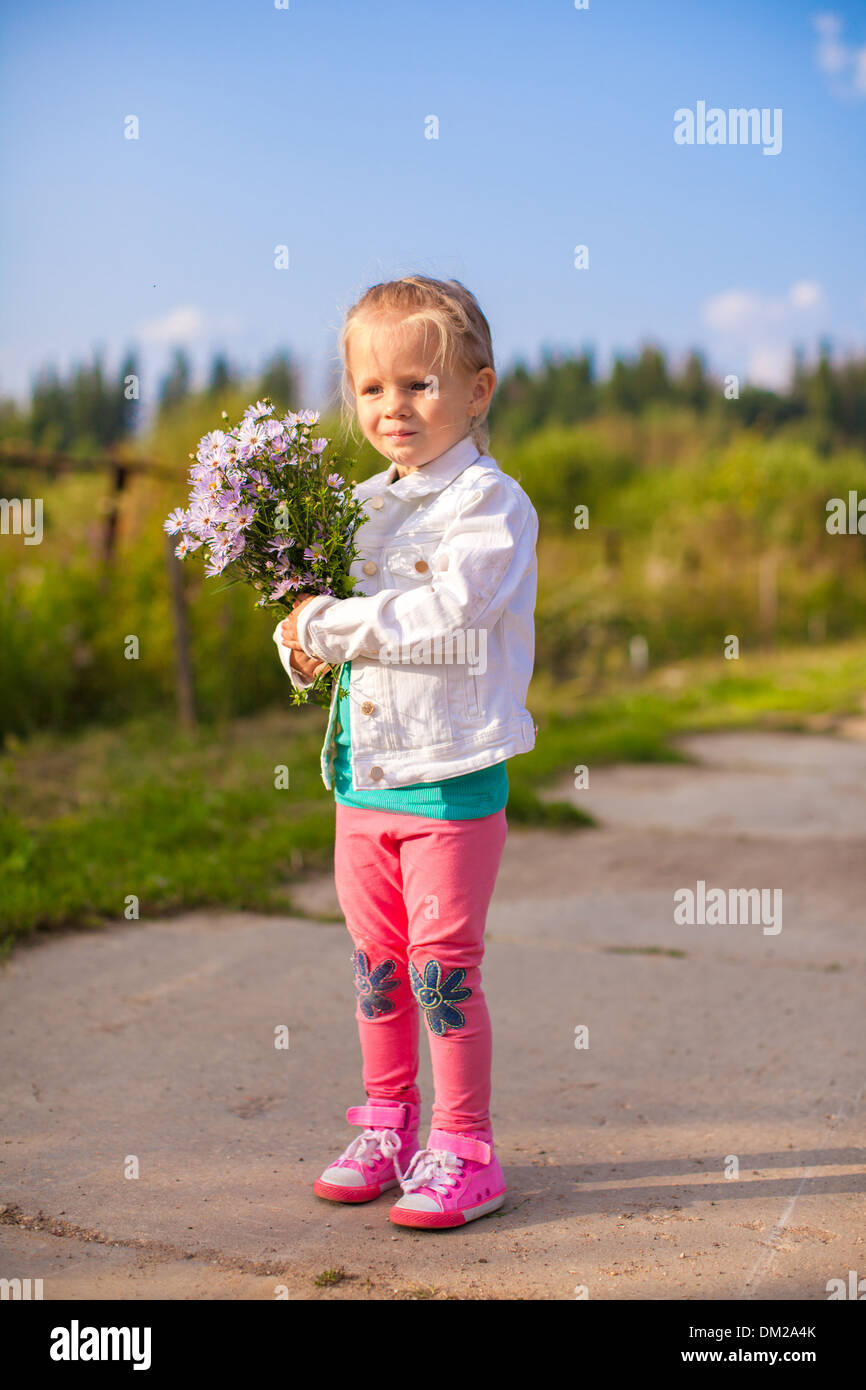 Little cute girl walking with a bouquet of flowers Stock Photo - Alamy