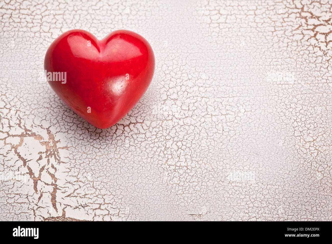 Valentines Day. Red heart on a white craquelure wooden table. Stock Photo