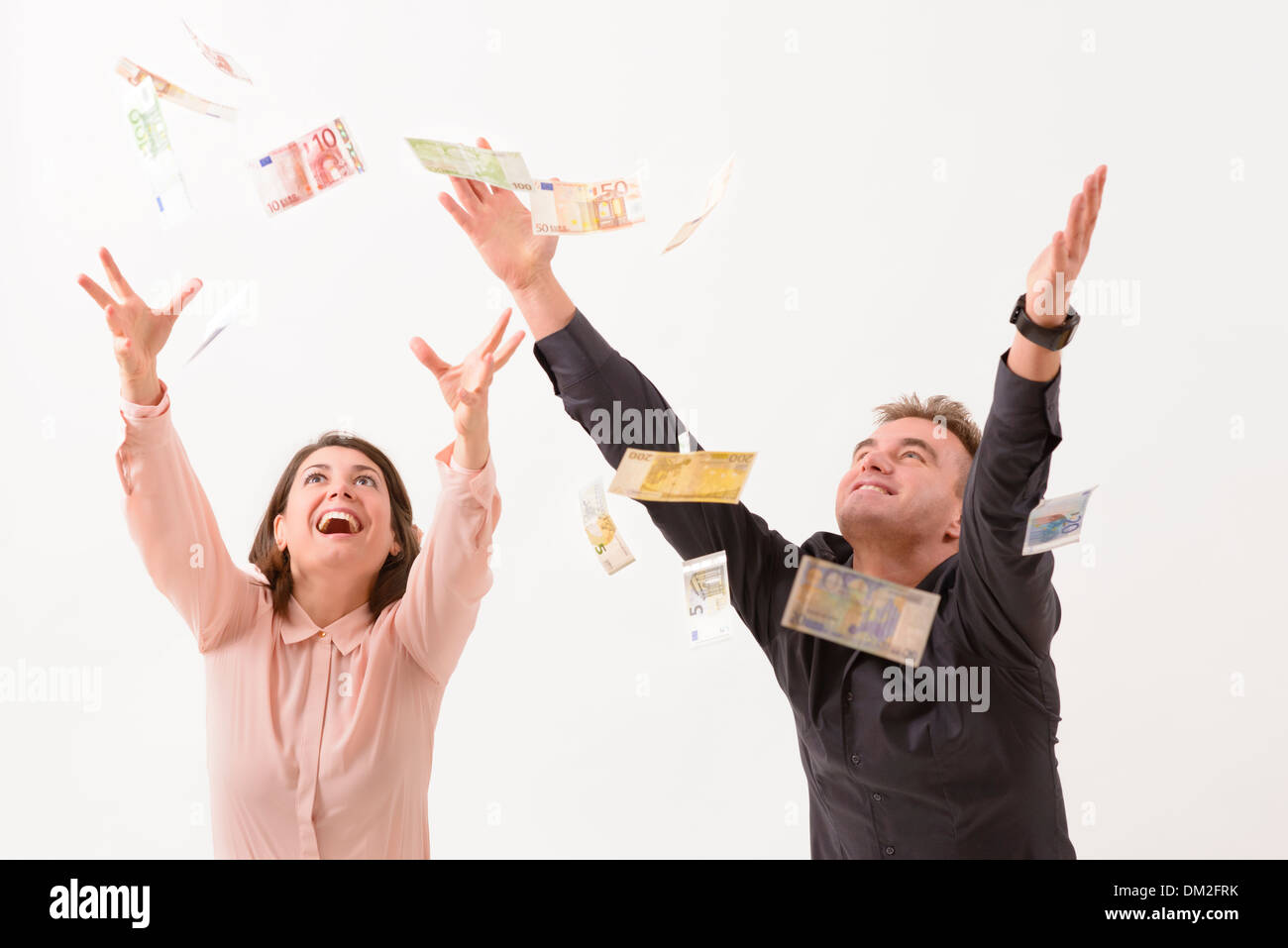 Young couple catching falling money Stock Photo