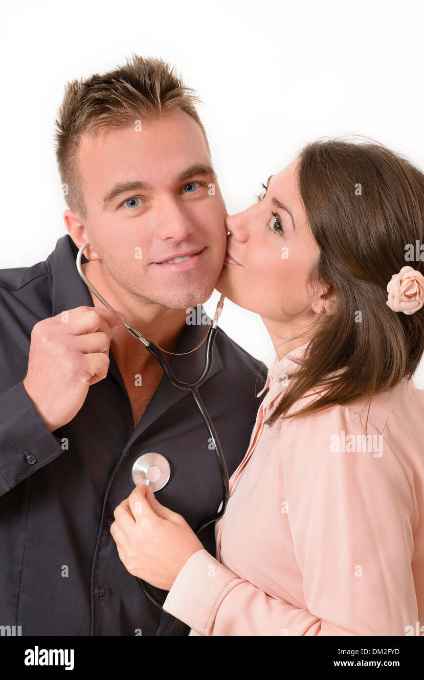 Pretty woman kissing a man which is listening to his heartbeats Stock Photo