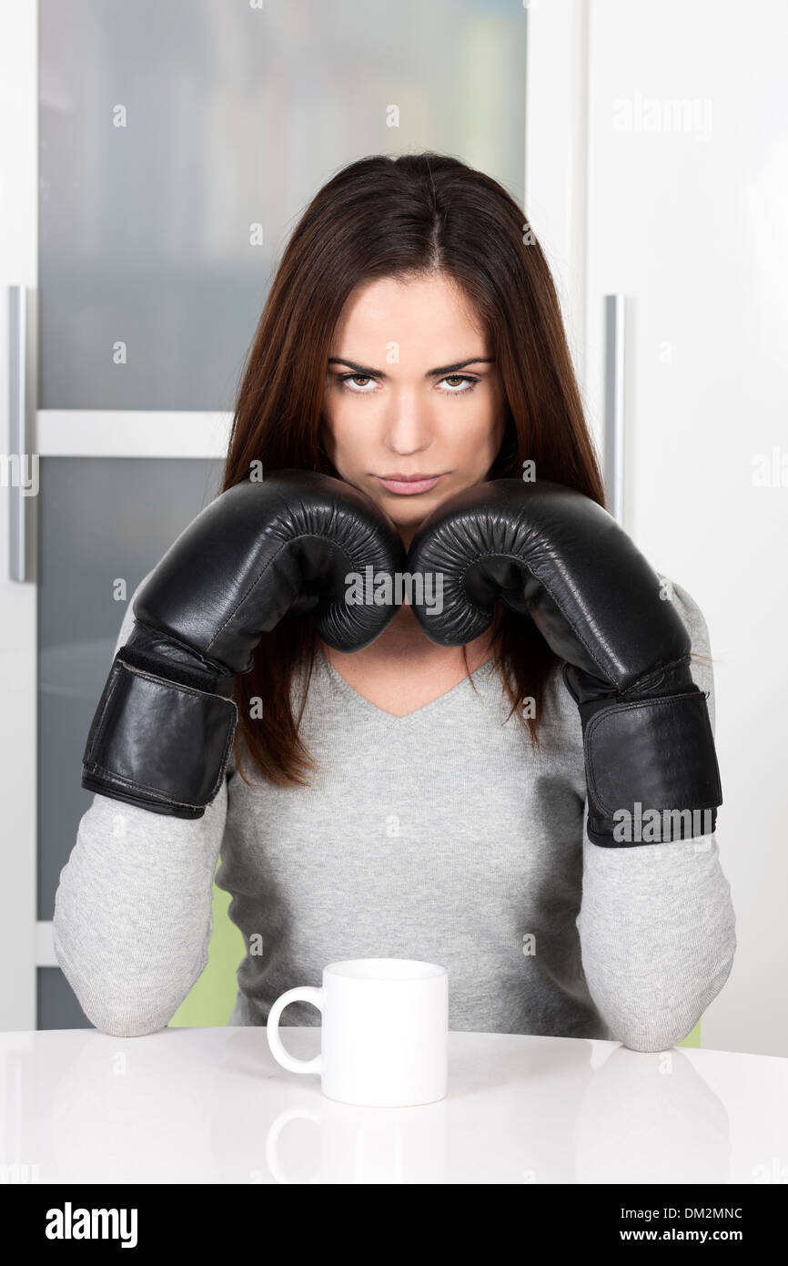 very tired looking woman early in the morning drinking a cup of coffee Stock Photo