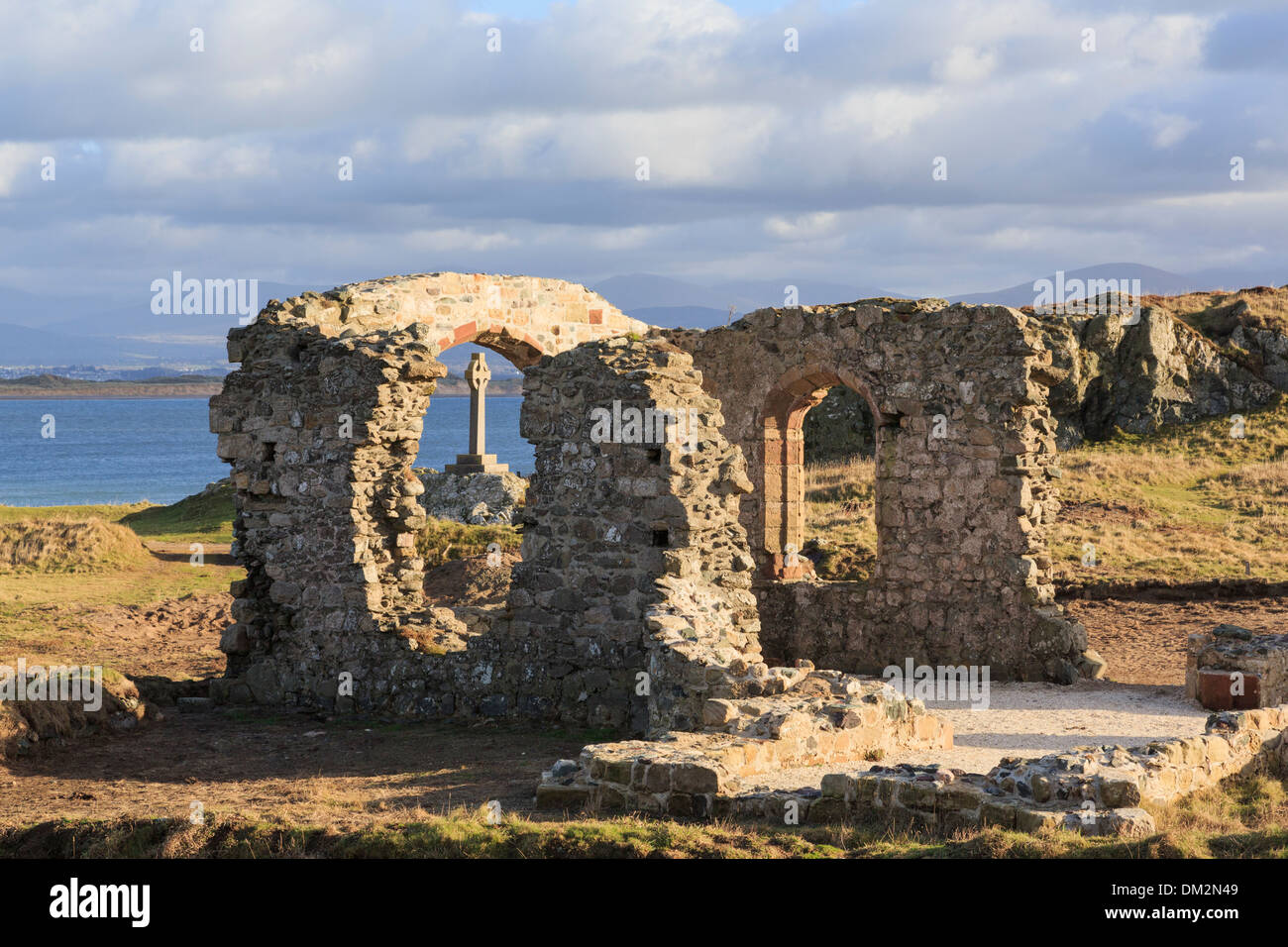Historic 16th century ruins of St Dwynwen's church with Celtic cross on Ynys Llanddwyn Island, Isle of Anglesey, North Wales, UK Stock Photo