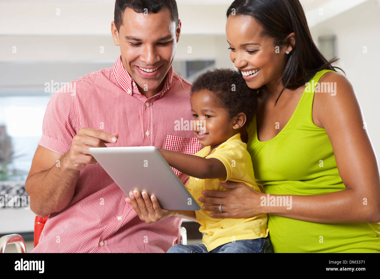 Family Using Digital Tablet In Kitchen Together Stock Photo