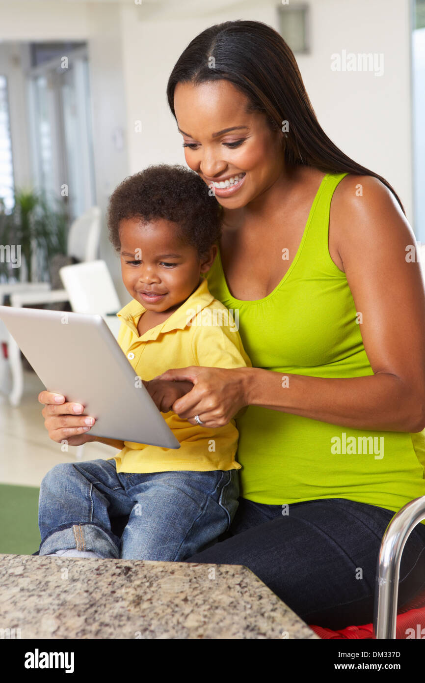 Mother And Son Using Digital Tablet In Kitchen Together Stock Photo