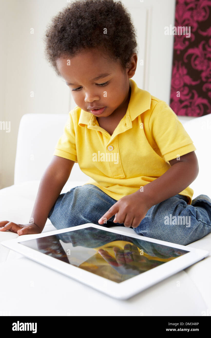 Happy Boy On Sofa Playing With Digital Tablet Stock Photo