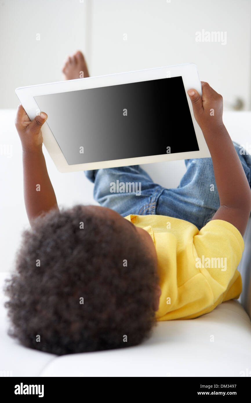 Happy Boy On Sofa Playing With Digital Tablet Stock Photo