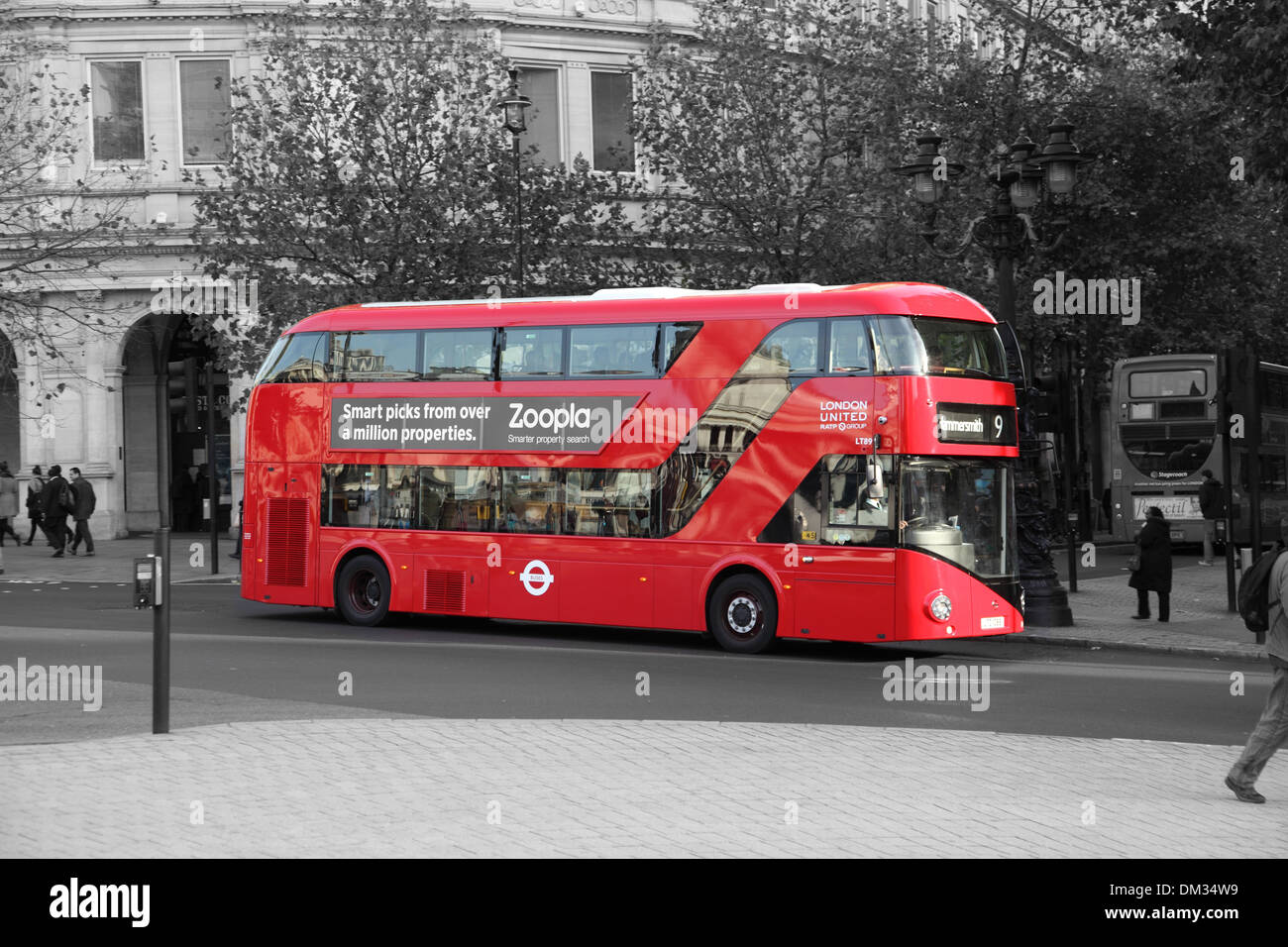A new Routemaster bus in red against a black and white background. Shown in London's Trafalgar Square. Stock Photo
