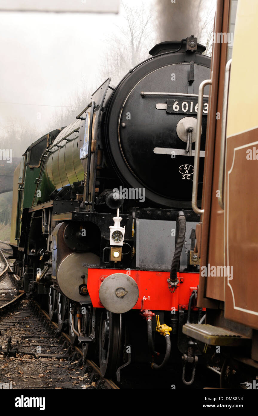 Steam engine pulling a coach out of the station Stock Photo