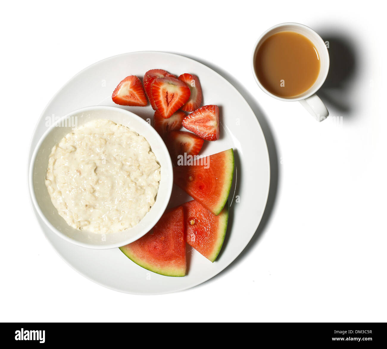 Bowl of porridge and fruit cut out on white background Stock Photo