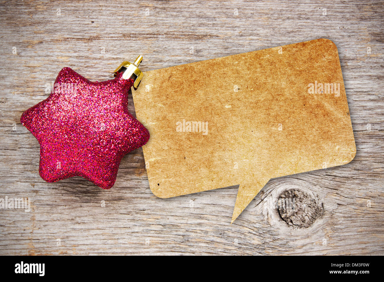 Blank recycled paper speech bubble with Christmas bauble on wood background Stock Photo
