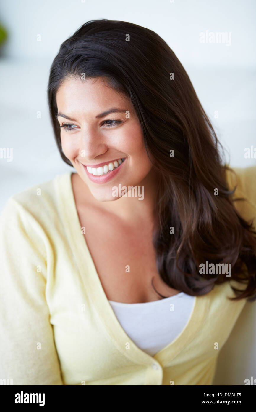 Smiling Woman Sitting On Sofa Stock Photo