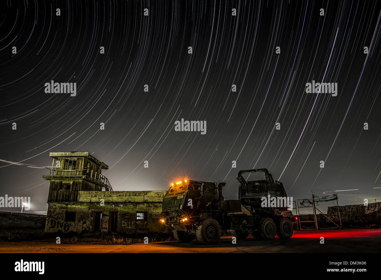 Stars trail across the Afghanistan night sky in a time-lapse photo with a High Mobility Artillery Rocket System at a undisclosed location in Afghanistan. Stock Photo