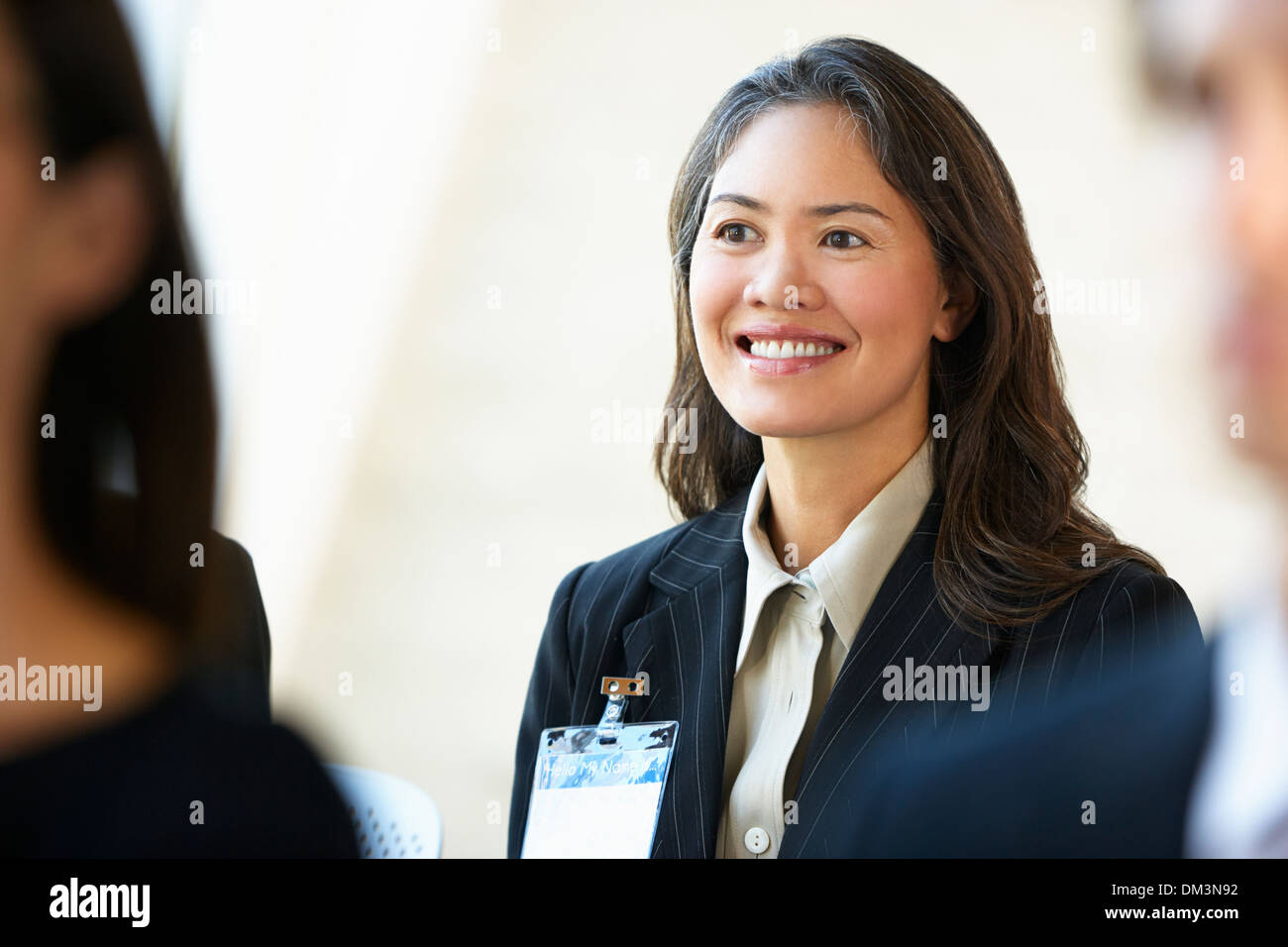 Businesswoman Listening To Speaker At Conference Stock Photo