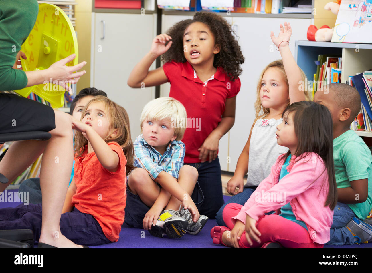 Elementary Pupils In Classroom Learning To Tell The Time Stock Photo