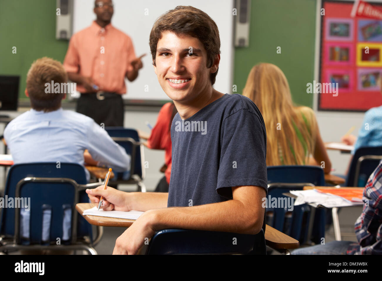 Male Teenage Pupil In Classroom Stock Photo