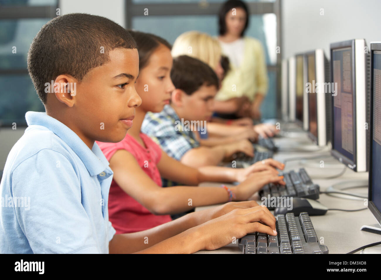 Elementary Students Working At Computers In Classroom Stock Photo