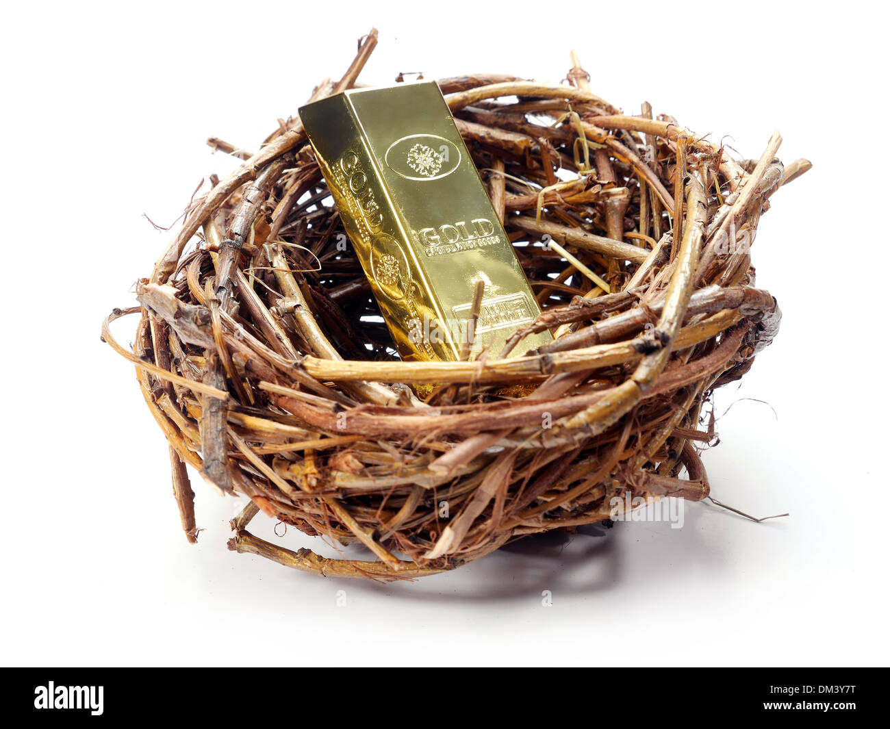 Gold bar in bird's nest over white background Stock Photo