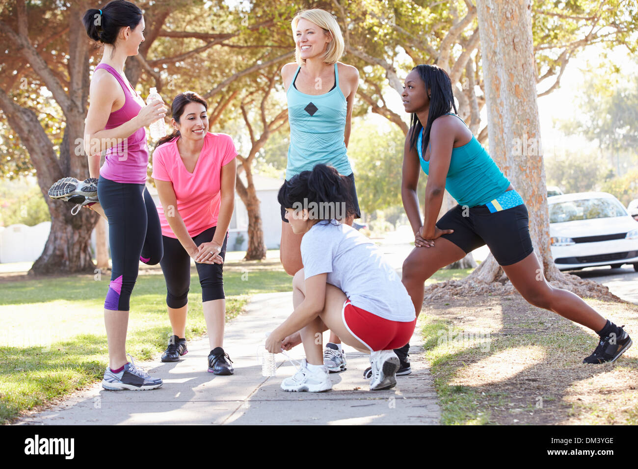 Group Of Female Runners Warming Up Before Run Stock Photo